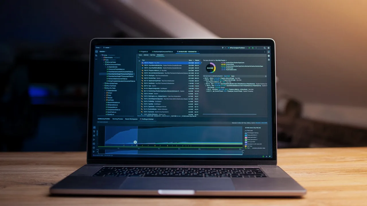 Laptop com a tela escura mostrando linhas de código, num ambiente de trabalho